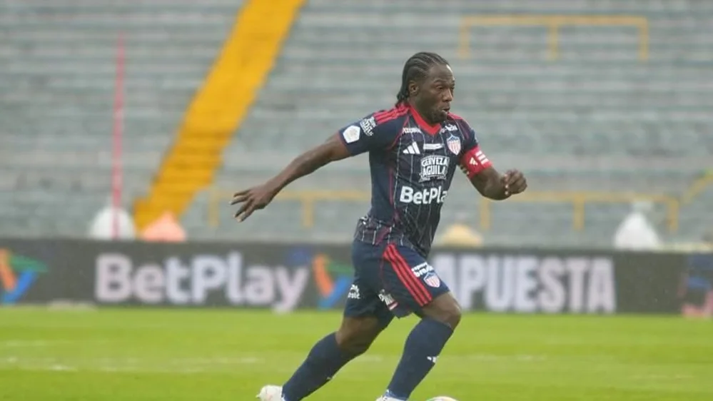 Fotografía de Yimmi Chará, extremo de Junior, transportando el balón en el partido contra Santa Fe.