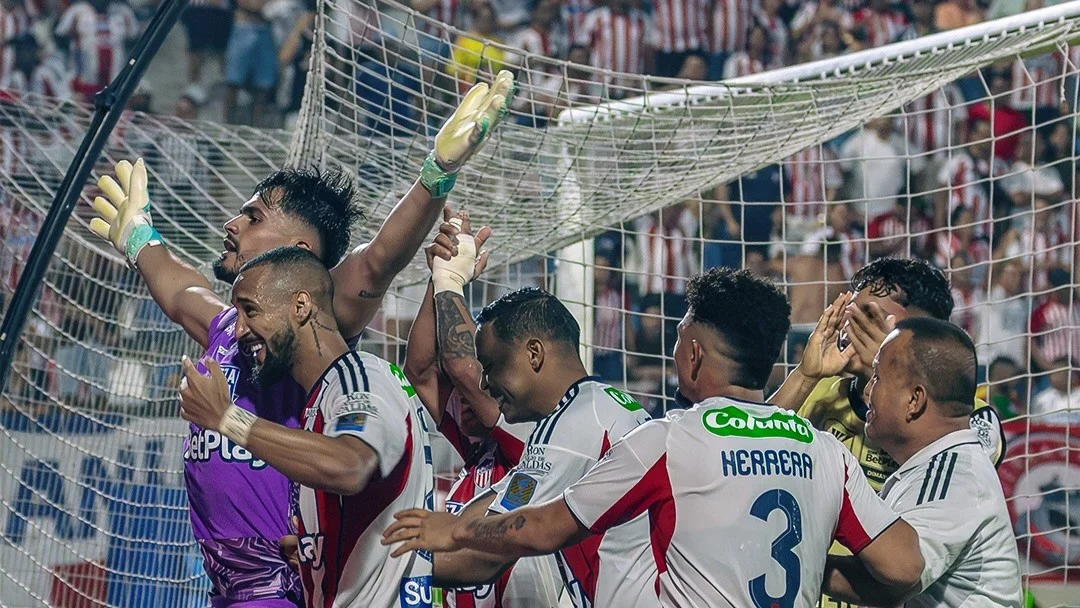 Fotografía de Mauro Silveira, portero de Junior, celebrando con sus compañeros el penal que atajó.